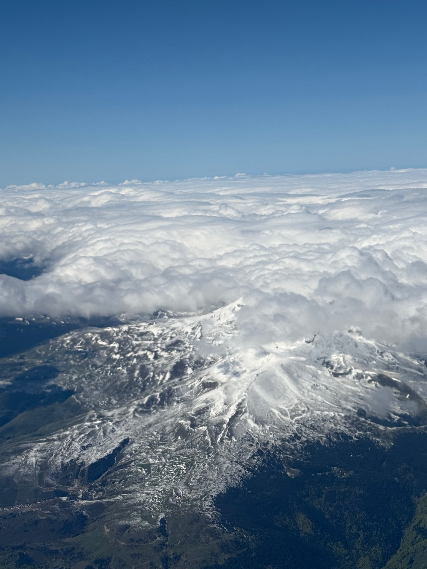 Snow-covered mountain peaks rising above a sea of cloud in the Kosovo highlands