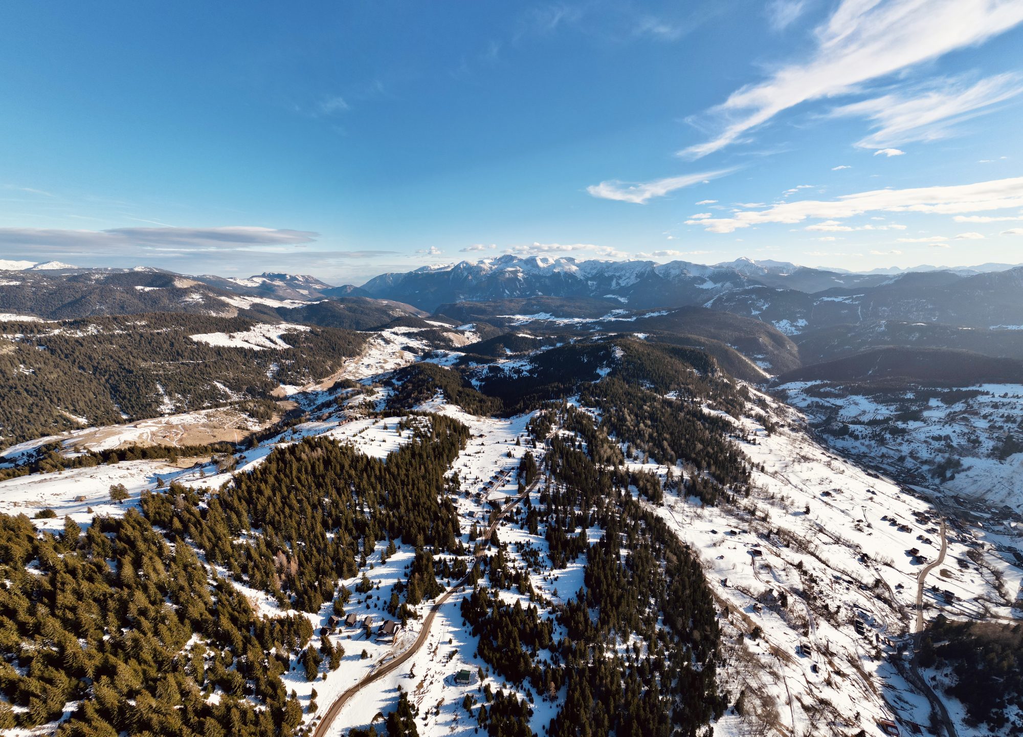 Boga in the Rugova mountains under deep winter snow, pine forest and chalets beneath the peaks