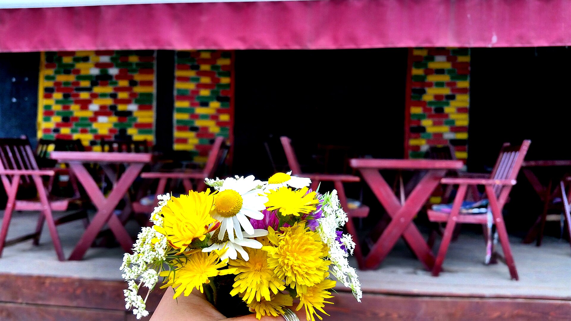 Colourful café terraces filled with tables and chairs on a street in central Prishtina, Kosovo